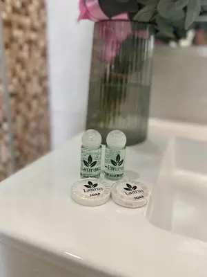a white counter with a vase and two rolls of toiletries at Laurus Motel Airport Tuzla in Živinice