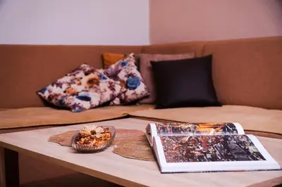 a table with a book and a bowl of food on a couch at Eden Visoko in Visoko
