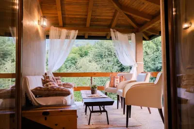 a living room with white chairs and a window at Eden Visoko in Visoko