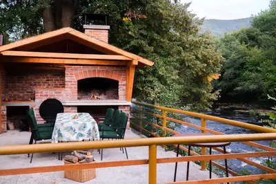 a patio with a fireplace and a table and chairs at Eden Visoko in Visoko