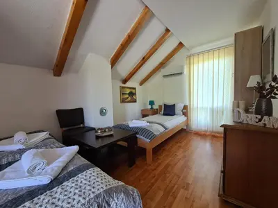 a bedroom with two beds and a desk in a room at Orhidea in Bihać