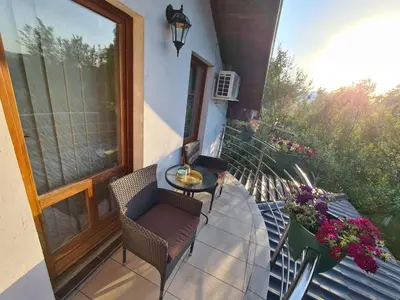 a balcony with a table and chairs on a porch at Orhidea in Bihać