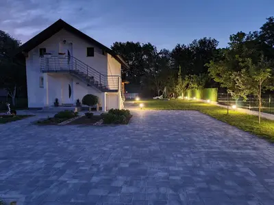 a driveway leading to a house at night at Orhidea in Bihać