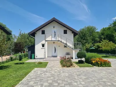 a white house with a balcony and a driveway at Orhidea in Bihać