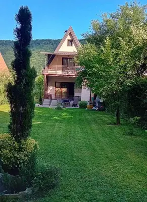 a large house with a yard with green grass at Tammaris Holiday Home in Visoko
