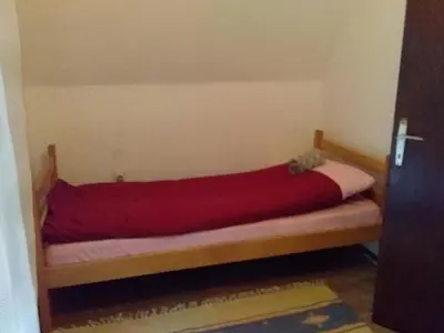 a bed with a red blanket on it in a room at Tammaris Holiday Home in Visoko