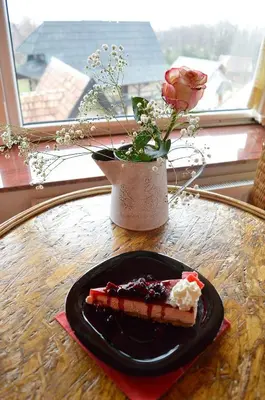 a plate of food on a table with a vase with a flower at Ski Rostovo - Hotel Rostovo & Ethno Village in Čardaci