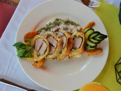 a plate of food with meat and fries on a table at Ski Rostovo - Hotel Rostovo & Ethno Village in Čardaci