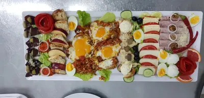a plate of food with eggs and vegetables on it at Ski Rostovo - Hotel Rostovo & Ethno Village in Čardaci