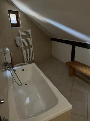 a white bath tub in a bathroom with a toilet at Ski Rostovo - Hotel Rostovo & Ethno Village in Čardaci