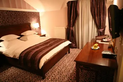 a hotel room with a bed and a wooden table at Hotel Villa Viktorija in Banja Luka