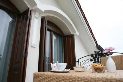 a table with cups and plates on a balcony at Hotel Villa Viktorija in Banja Luka