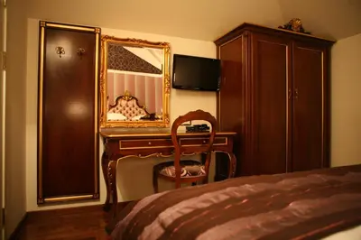 a bedroom with a desk and a mirror and a bed at Hotel Villa Viktorija in Banja Luka