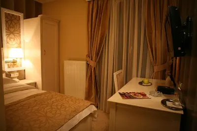 a bedroom with a bed and a desk with a lamp at Hotel Villa Viktorija in Banja Luka