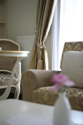 a living room with a couch and a chair and a table at Hotel Villa Viktorija in Banja Luka