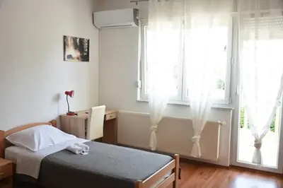 a bedroom with a bed and two windows at Apartman Nikolic,Banja Vrucica,Teslic in Teslić