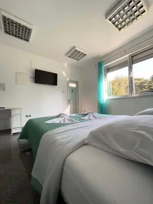 a bedroom with a large bed and a tv on the wall at Apartman Nikolic,Banja Vrucica,Teslic in Teslić