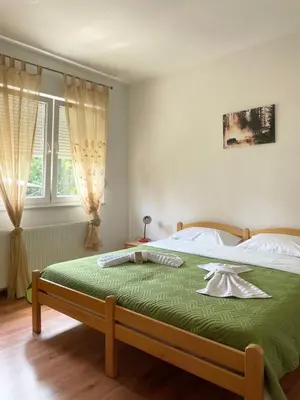 a bedroom with a large bed with a green blanket at Apartman Nikolic,Banja Vrucica,Teslic in Teslić