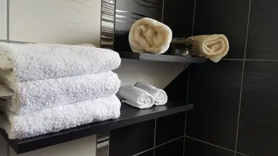 a bunch of towels on a shelf in a bathroom at Luxury house 