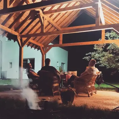a group of people sitting under a wooden pergola at Luxury house 