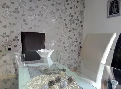 a glass table in a room with flowers on a wall at Luxury house 