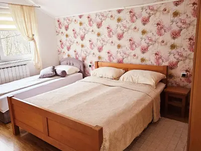 two beds in a bedroom with pink floral wallpaper at Luxury house 