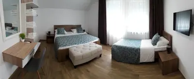a bedroom with two beds and a couch and a desk at Amal Grand Villa in Bihać