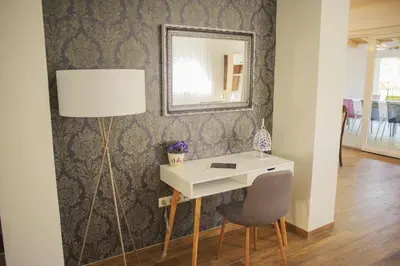 a desk with a mirror and a chair in a room at Amal Grand Villa in Bihać