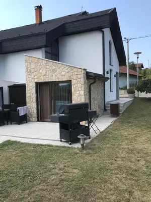 a house with a grill on a patio at Luxeriöse Villa mit Bergblick in Donji Ljenobud
