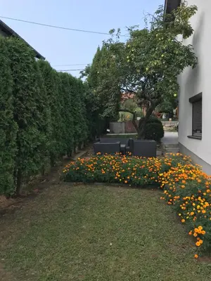 a garden with flowers on the side of a building at Luxeriöse Villa mit Bergblick in Donji Ljenobud