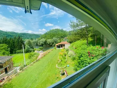 a view of a garden from a window of a house at Unaqua Apartments in Kulen Vakuf