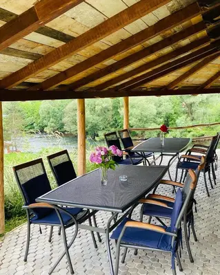 a group of tables and chairs on a patio at Unaqua Apartments in Kulen Vakuf