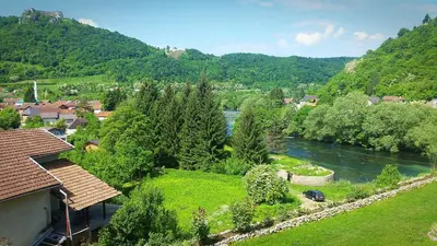 a view of a river in a town next to a mountain at Unaqua Apartments in Kulen Vakuf