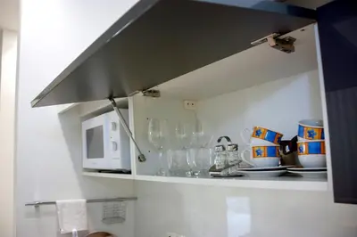 a kitchen with a counter with glasses and a microwave at Villa Onix in Bihać