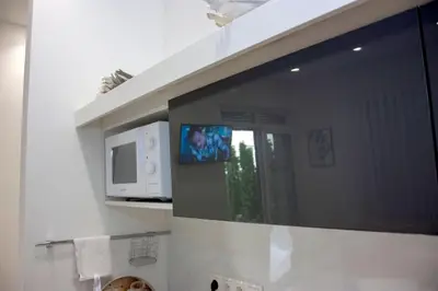 a bathroom mirror with a tv and a microwave at Villa Onix in Bihać