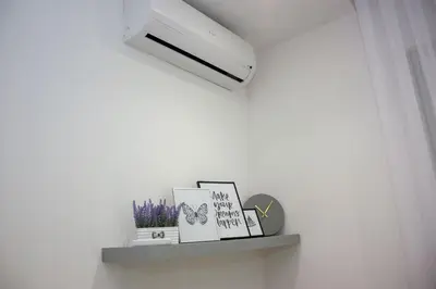 a shelf with books and a air conditioner on a wall at Villa Onix in Bihać