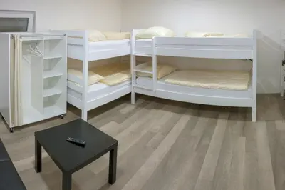 a room with white bunk beds and a table at Villa Onix in Bihać