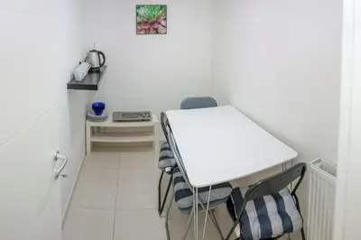 a small kitchen with a white table and chairs at Villa Onix in Bihać