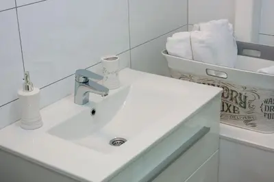 a white bathroom with a sink and a mirror at Villa Onix in Bihać
