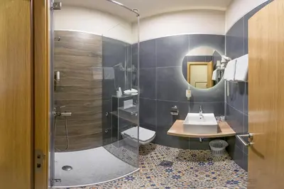a bathroom with a sink and a toilet and a mirror at Boutique Hotel St Georgije in Banja Luka