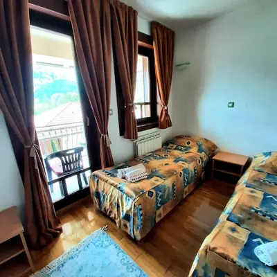 a bedroom with two beds and a window with a balcony at Relax Apartman sa garažom in Fojnica