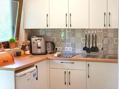 a kitchen with white cabinets and a counter top at Private Riverside House on the Una River with Private Beach in Kulen Vakuf