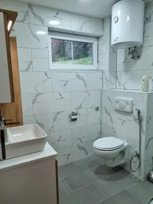 a white bathroom with a toilet and a sink at Private Riverside House on the Una River with Private Beach in Kulen Vakuf