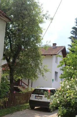 a white car parked in front of a house at Apartment Dil in Kulen Vakuf