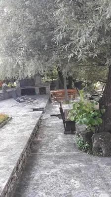 a park with two benches and a tree at Hideaway in Bihać
