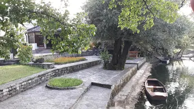 a boat sitting in the water next to a house at Hideaway in Bihać
