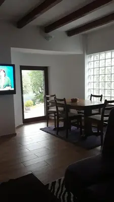 a dining room with a table and a tv at Hideaway in Bihać