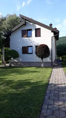 a white house with a tree in the yard at Hideaway in Bihać