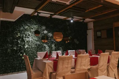 a dining room with tables and chairs and a green wall at Motel West in Zenica