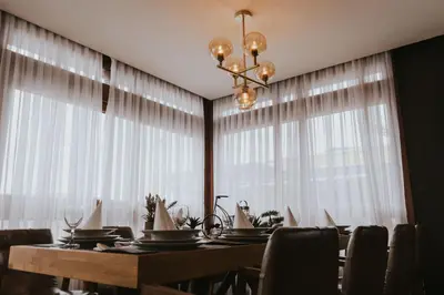 a dining room with a table and a chandelier at Motel West in Zenica